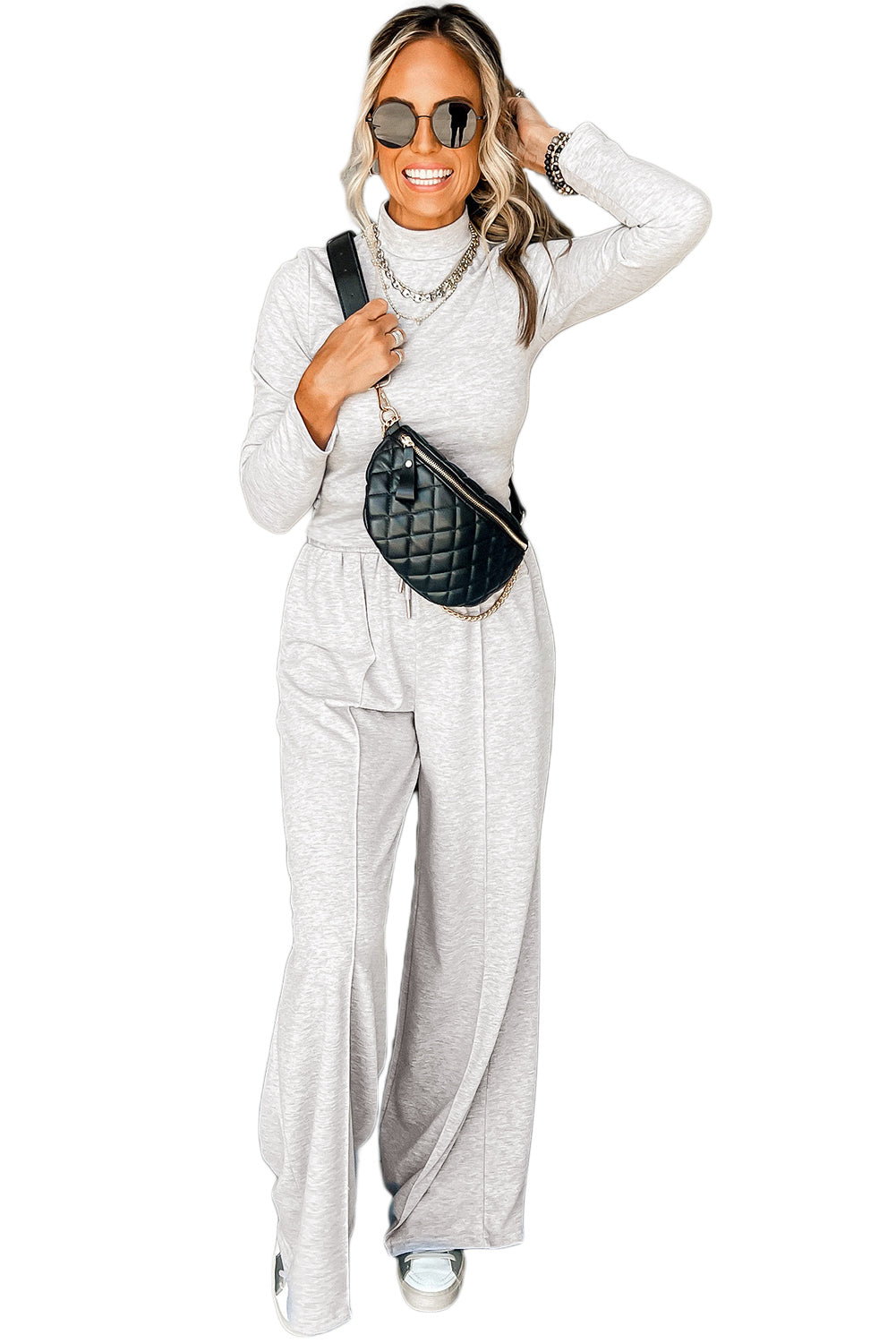 Lichtgrijze top met lange mouwen hoge hals en broek met wijde pijpen