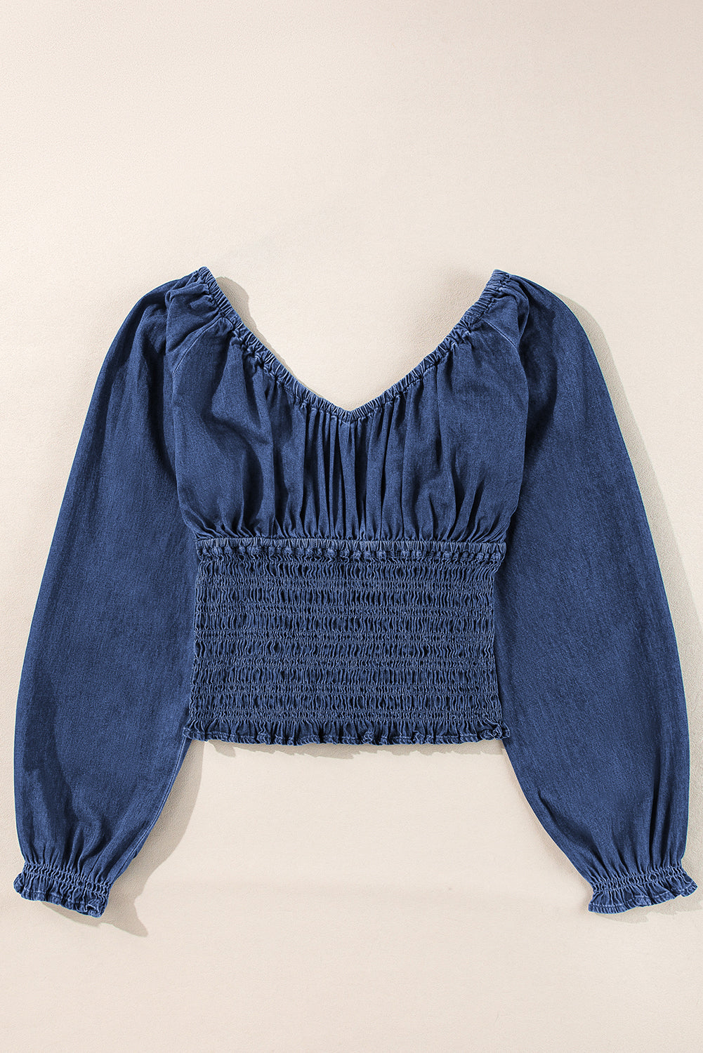 Blauwe denim top met smokwerk ruches pofmouwen en V-hals