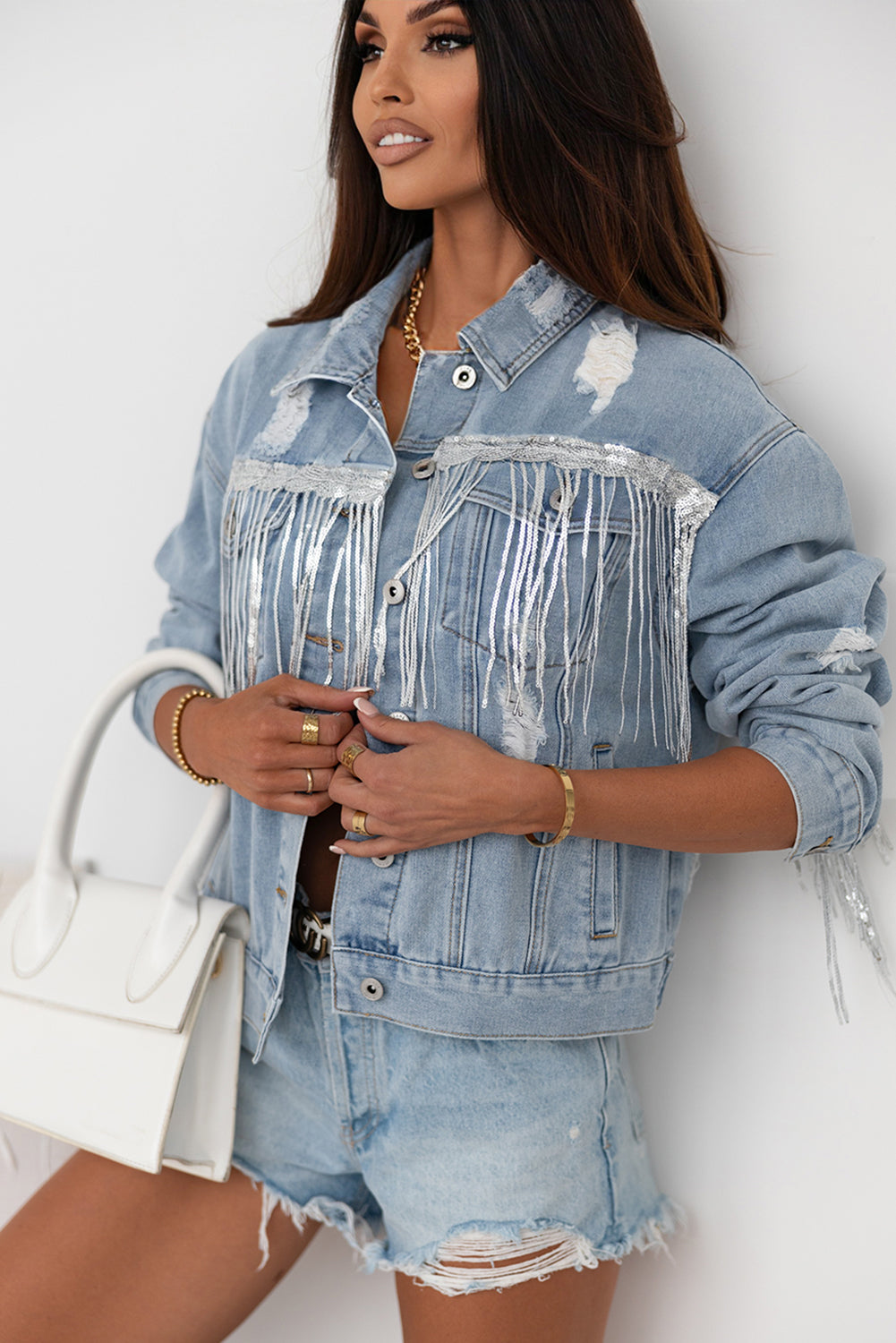 Hemelsblauwe denimjas met pailletten en franjes in een verweerde look