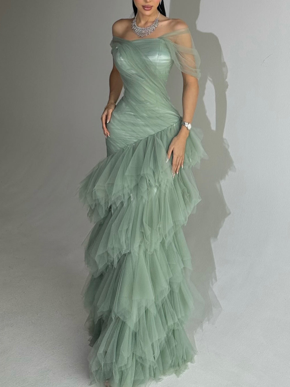 Elegante lichtgroene strapless zeemeerminjurk met gelaagde tule rok