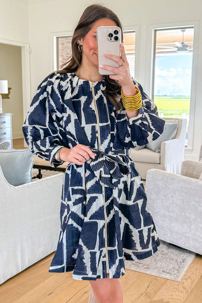 Blauwe jurk met abstracte geometrische print ritssluiting en strikceintuur