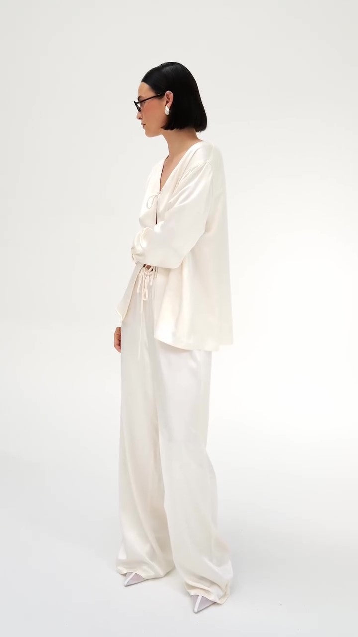 Set van crèmekleurige satijnen top met strik aan de voorkant en wijde broek