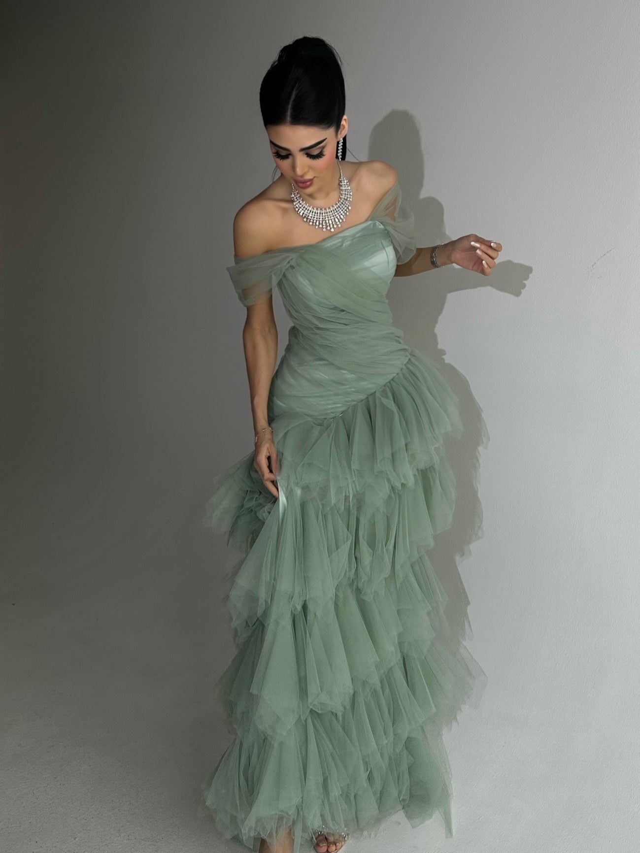 Elegante lichtgroene strapless zeemeerminjurk met gelaagde tule rok