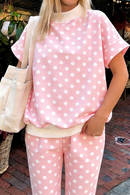 Roze top met stippenprint colkraag en korte mouwen gecombineerd met een recht broek