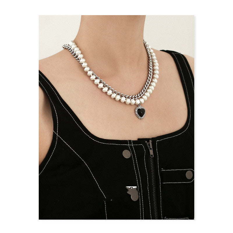 Gelaagde parelketting met een zilverkleurige ketting en hartvormige hanger