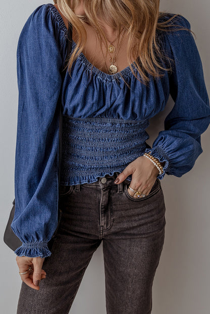 Blauwe denim top met smokwerk ruches pofmouwen en V-hals