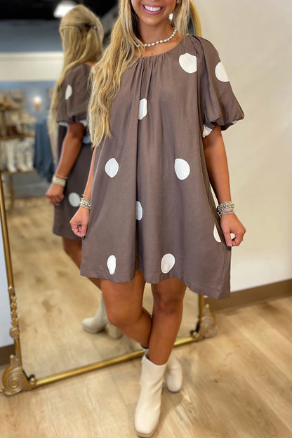 Bruine mini-jurk met stippenprint knoopsluiting op de rug en korte pofmouwen losvallend model