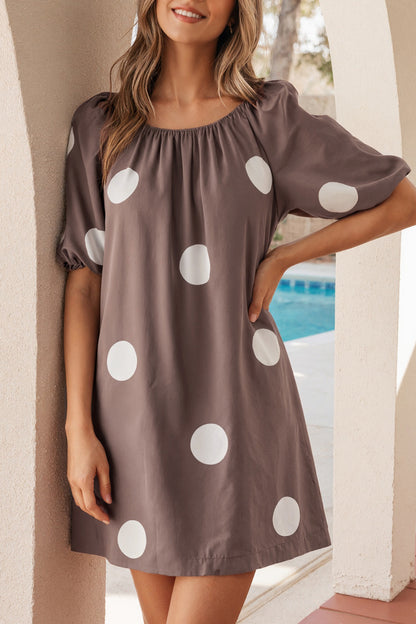 Bruine mini-jurk met stippenprint knoopsluiting op de rug en korte pofmouwen losvallend model
