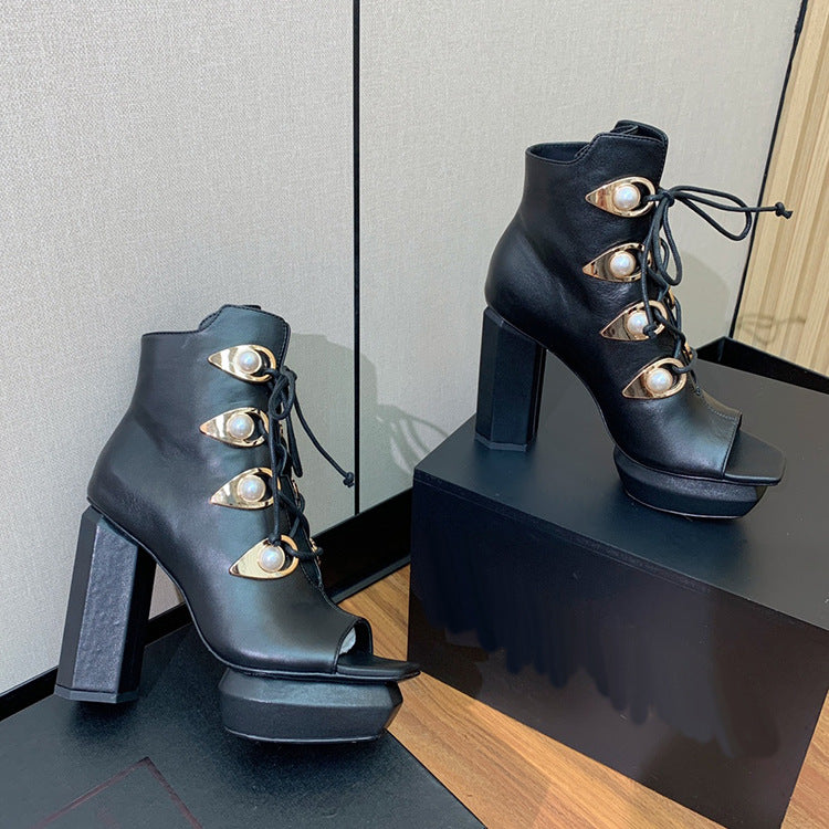 Luxe dameslaarzen van een designermerk met metalen versiering en open teen