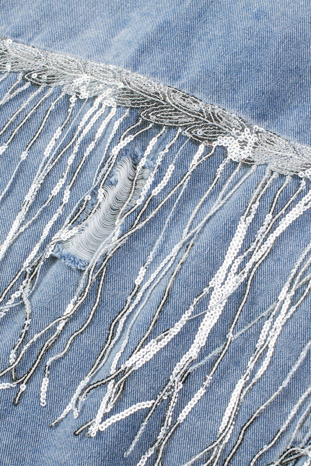 Hemelsblauwe denimjas met pailletten en franjes in een verweerde look