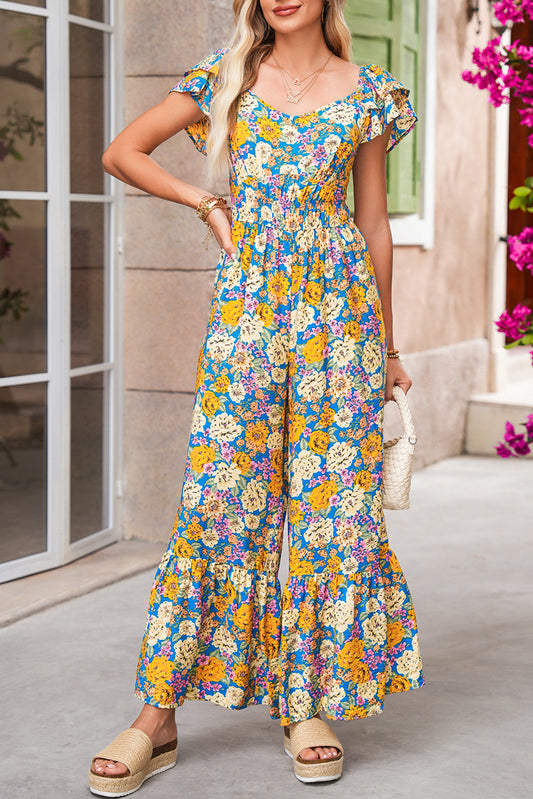 Gele jumpsuit met bloemenprint over de hele stof geplooide details en hoge taille