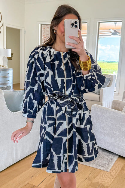 Blauwe jurk met abstracte geometrische print ritssluiting en strikceintuur