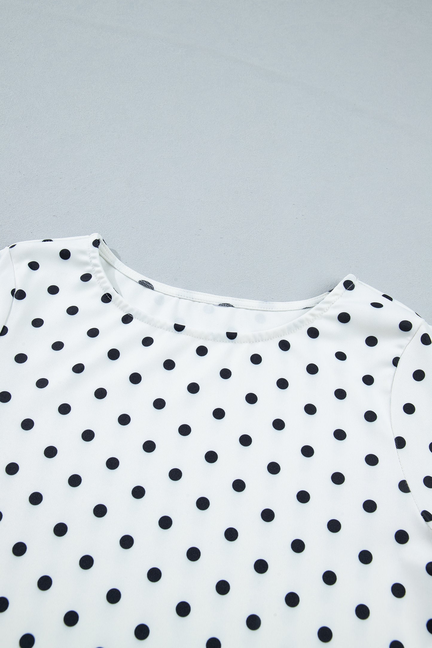 Witte top met lange mouwen en stippenprint en sla-afwerking