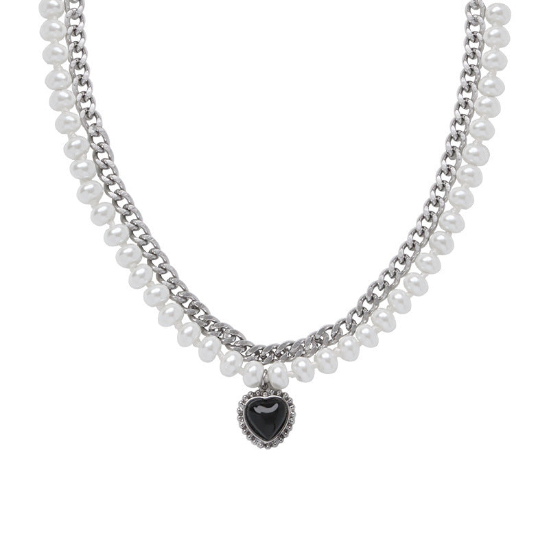 Gelaagde parelketting met een zilverkleurige ketting en hartvormige hanger