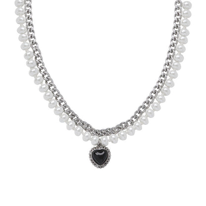 Gelaagde parelketting met een zilverkleurige ketting en hartvormige hanger