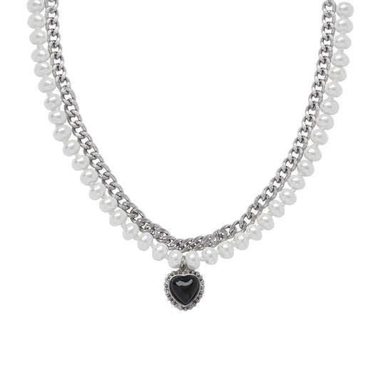 Gelaagde parelketting met een zilverkleurige ketting en hartvormige hanger