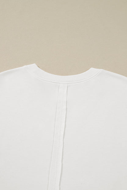 Witte plus-size sweatshirt met zichtbare naden contrasterende stippen en bloemenprint
