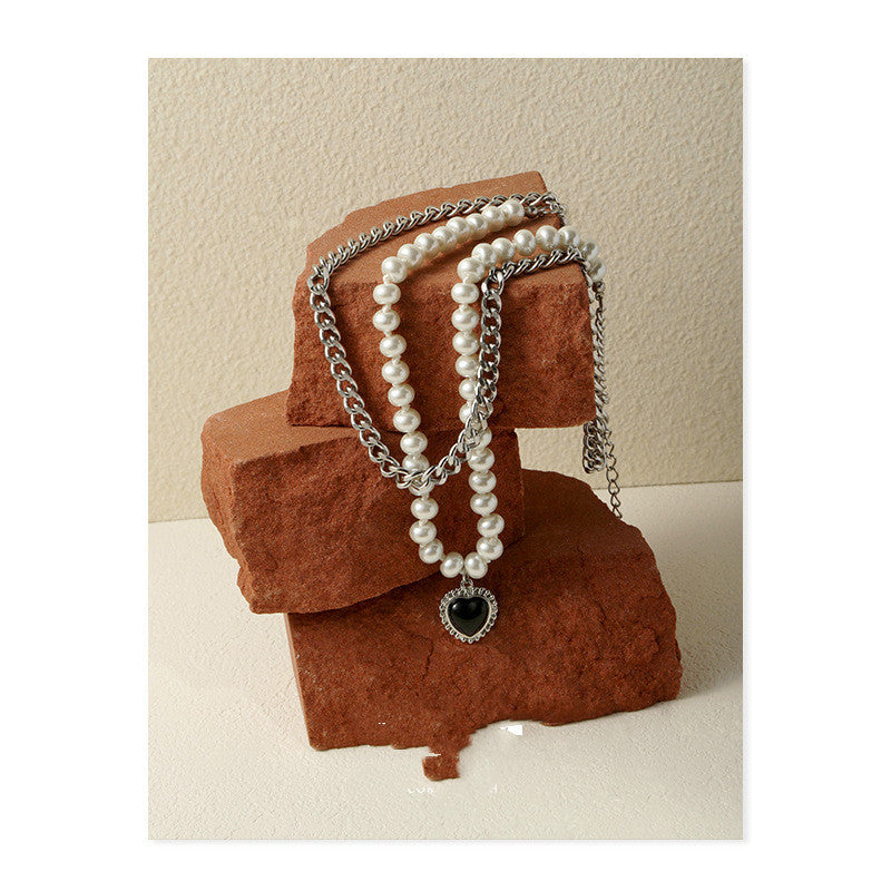 Gelaagde parelketting met een zilverkleurige ketting en hartvormige hanger
