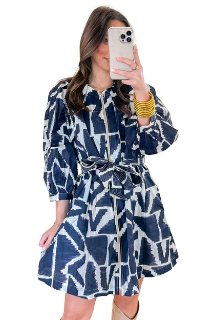 Blauwe jurk met abstracte geometrische print ritssluiting en strikceintuur