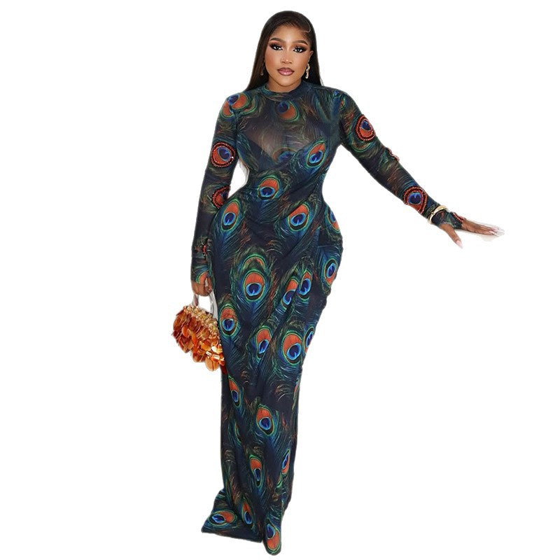 Getailleerde maxi-jurk met pauwenprint semi-transparant hoge hals en lange mouwen