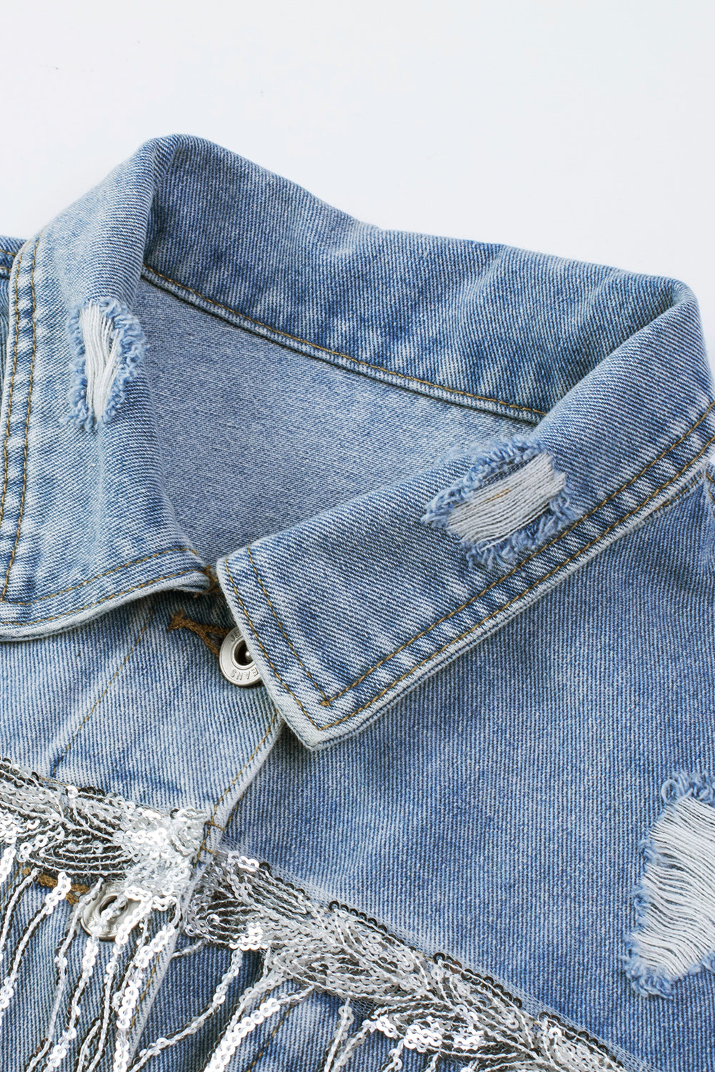 Hemelsblauwe denimjas met pailletten en franjes in een verweerde look