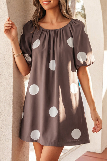 Bruine mini-jurk met stippenprint knoopsluiting op de rug en korte pofmouwen losvallend model