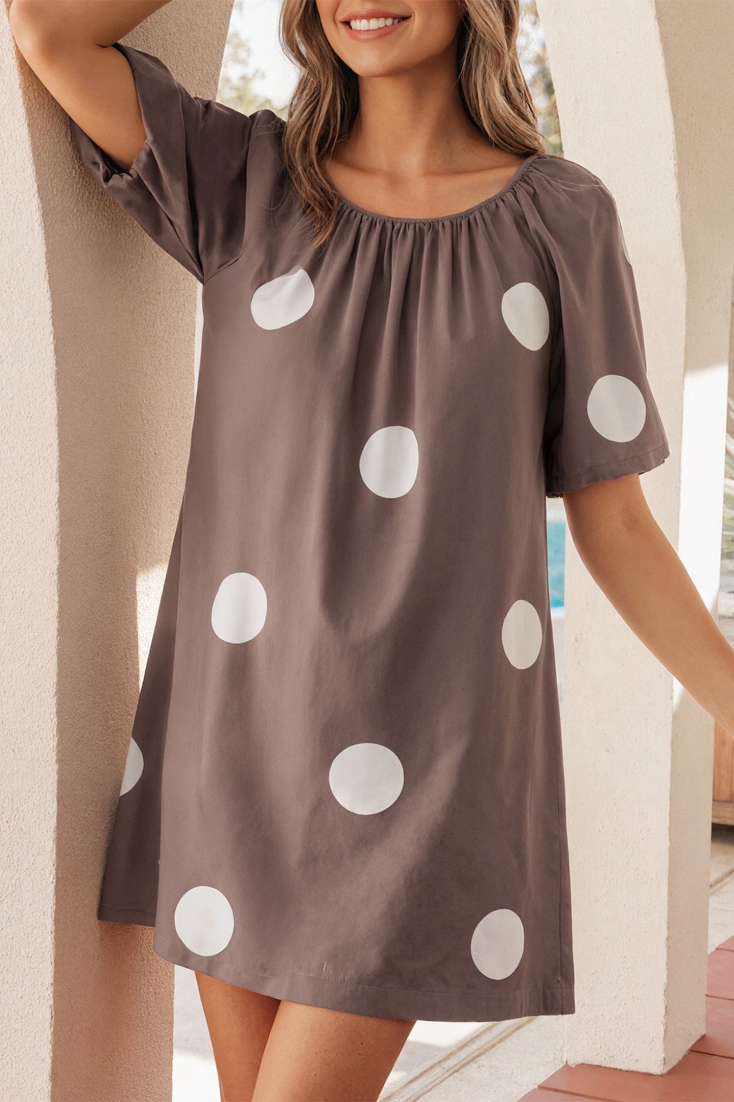 Bruine mini-jurk met stippenprint knoopsluiting op de rug en korte pofmouwen losvallend model