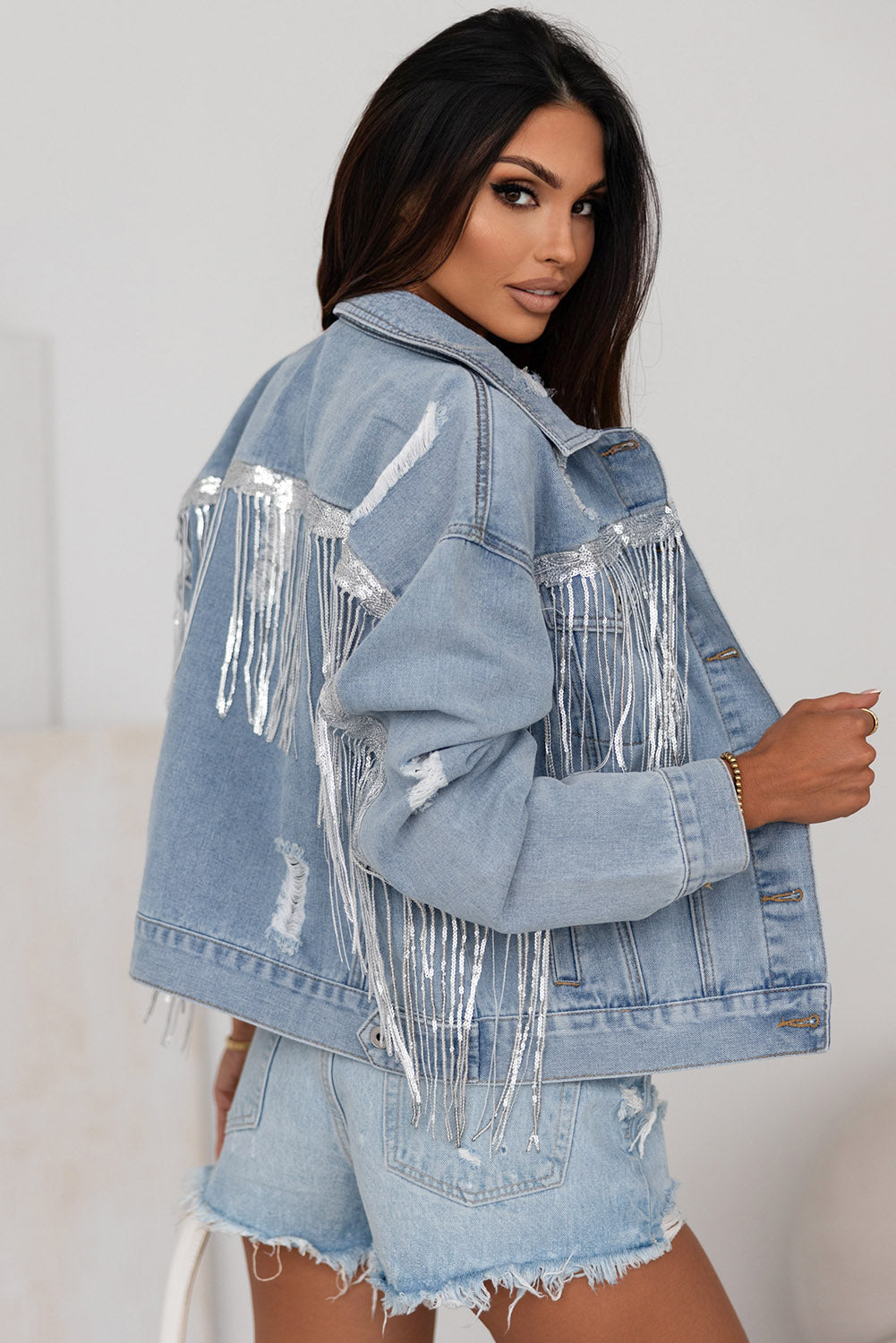Hemelsblauwe denimjas met pailletten en franjes in een verweerde look
