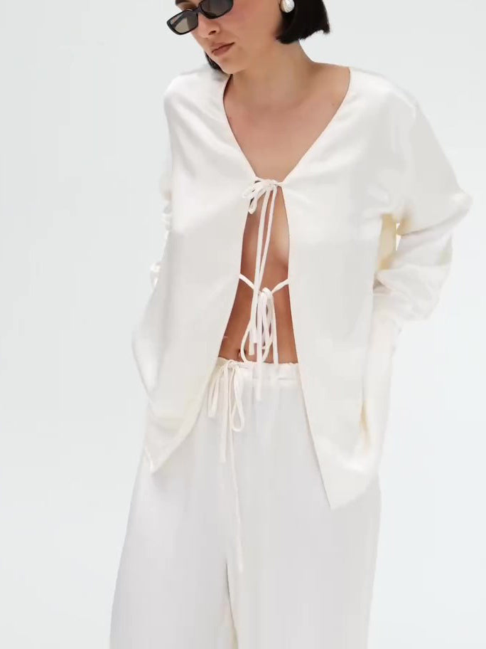 Set van crèmekleurige satijnen top met strik aan de voorkant en wijde broek