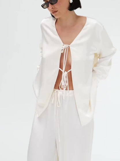 Set van crèmekleurige satijnen top met strik aan de voorkant en wijde broek