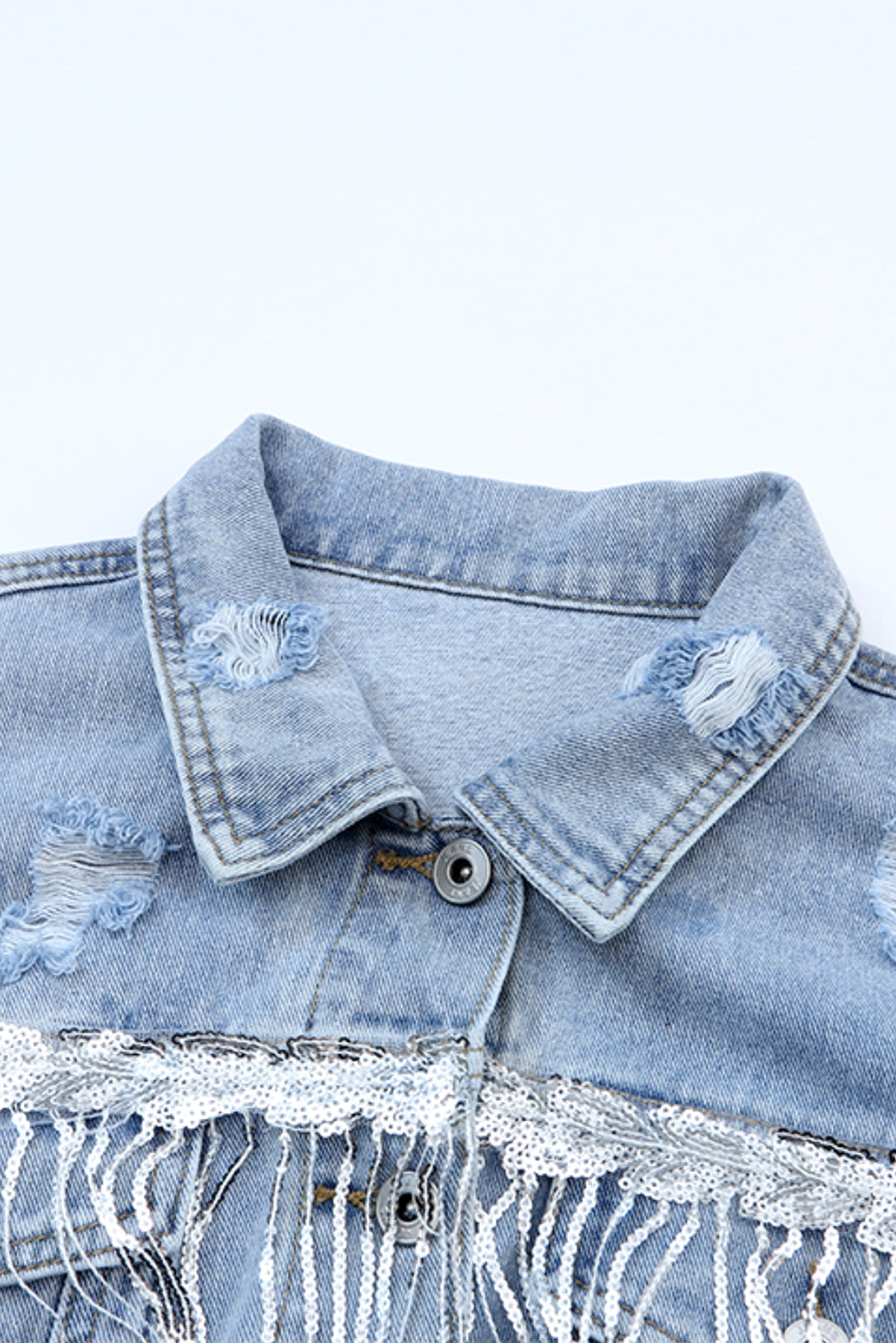 Hemelsblauwe denimjas met pailletten en franjes in een verweerde look
