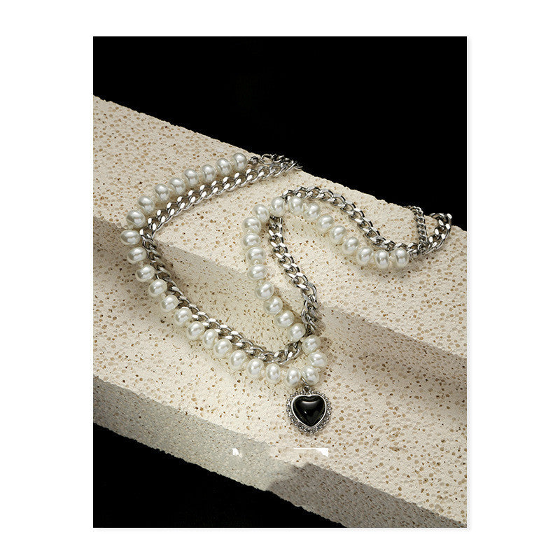 Gelaagde parelketting met een zilverkleurige ketting en hartvormige hanger