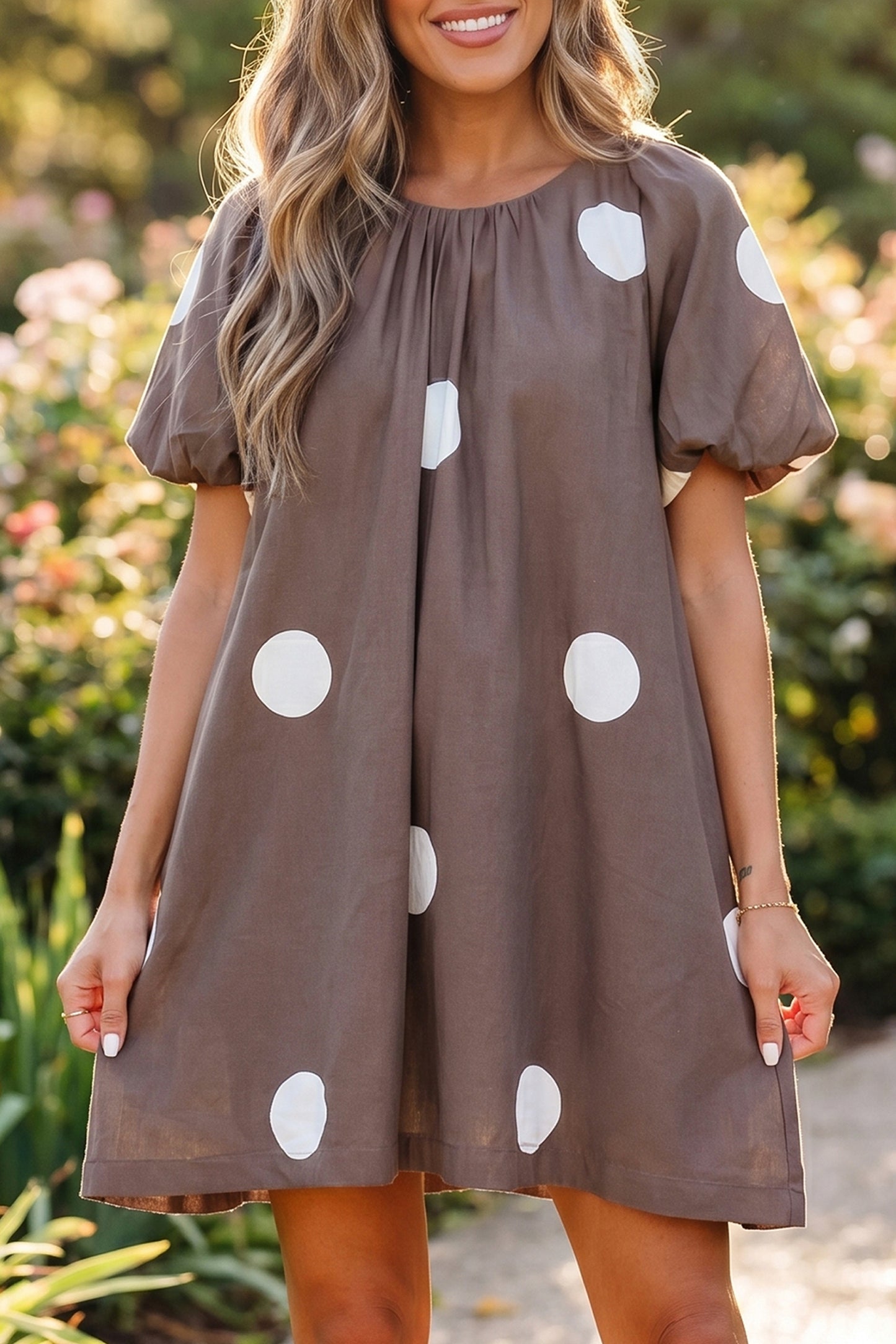 Bruine mini-jurk met stippenprint knoopsluiting op de rug en korte pofmouwen losvallend model