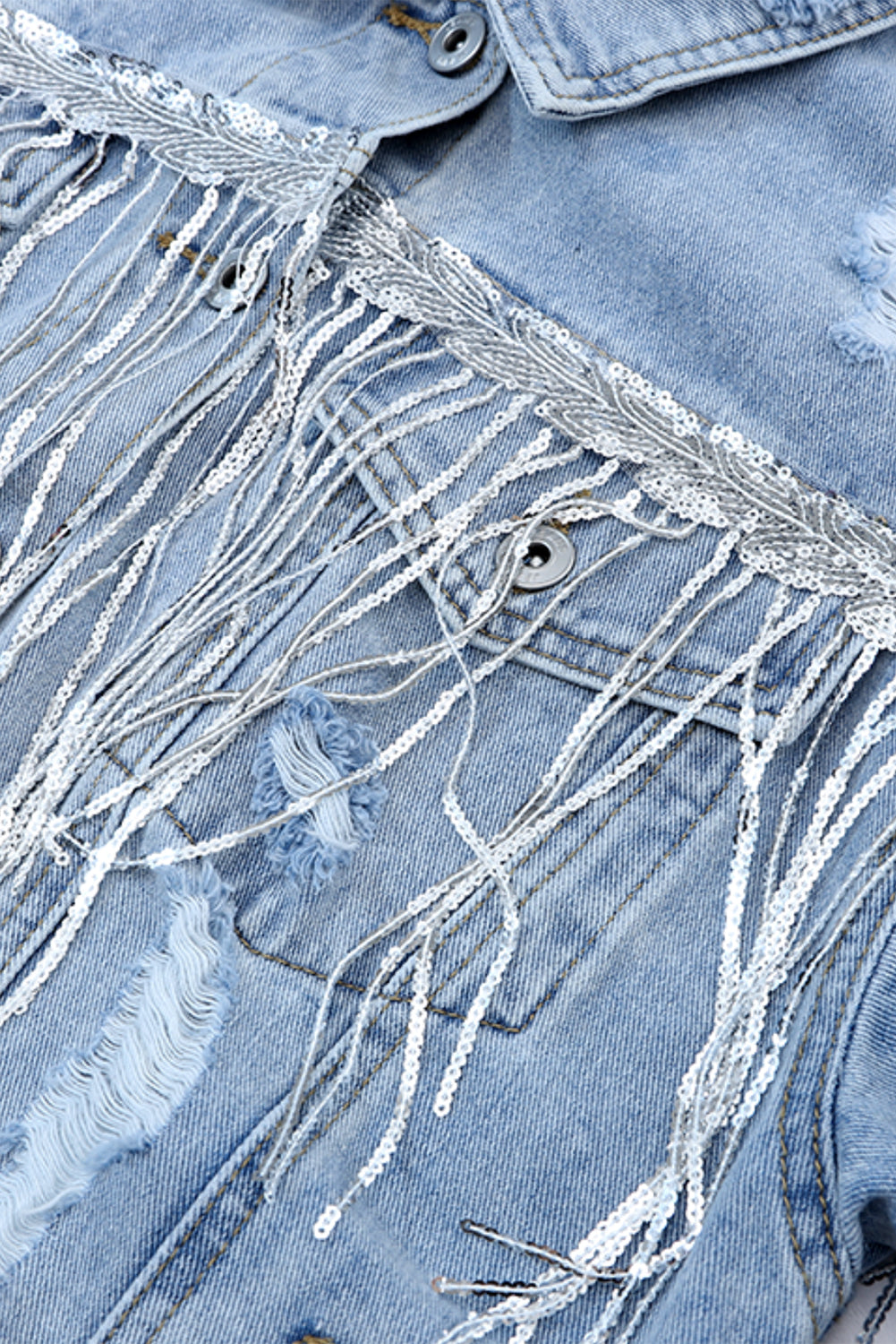 Hemelsblauwe denimjas met pailletten en franjes in een verweerde look